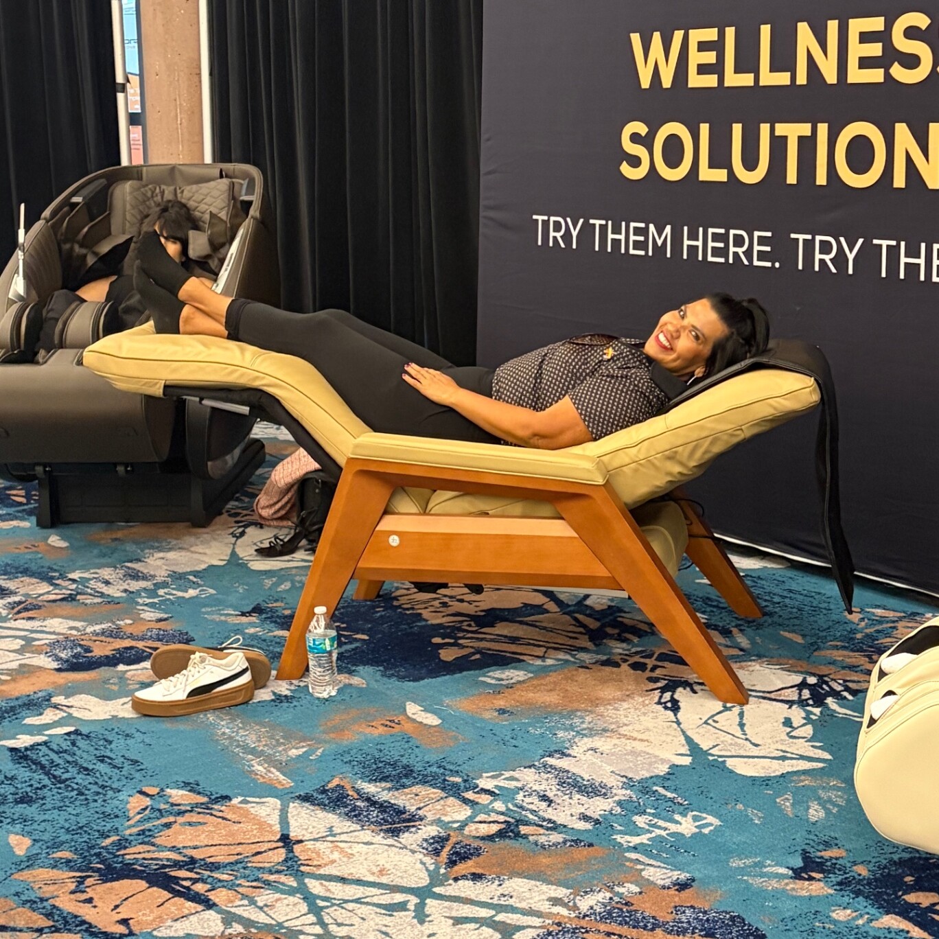 Guest relaxing in a Human Touch chair at a booth